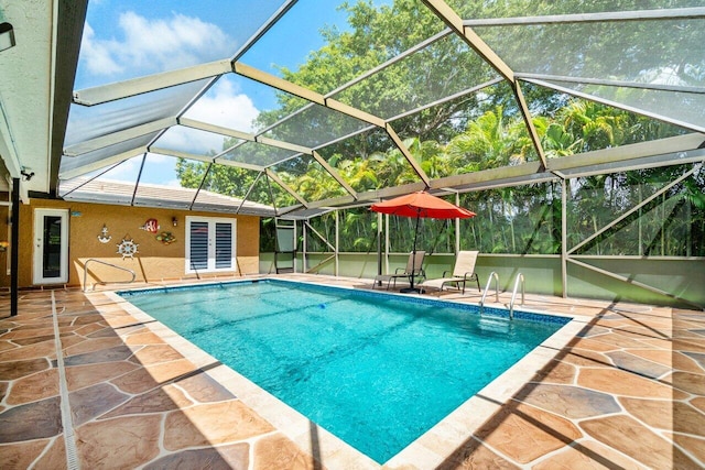 outdoor pool with a patio area, french doors, and glass enclosure