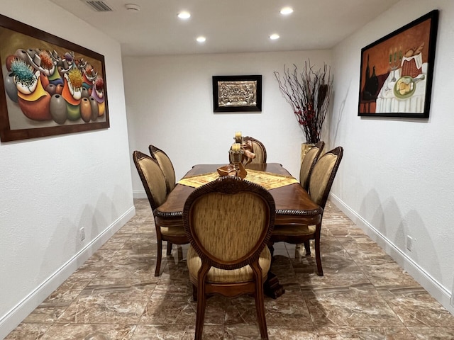 dining space featuring recessed lighting, baseboards, and stone finish floors