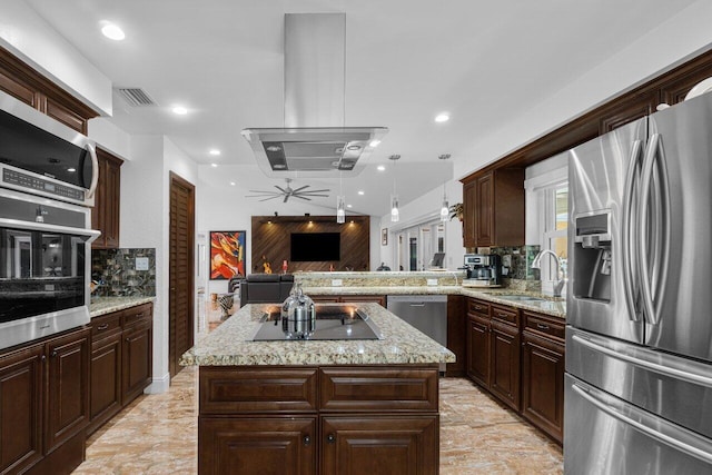 kitchen with stainless steel appliances, a ceiling fan, tasteful backsplash, open floor plan, and light stone countertops