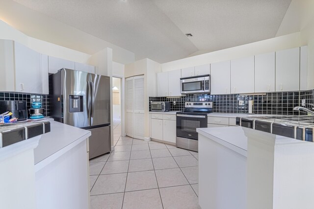 22234 Collington Dr, Boca Raton, FL 33428 - kitchen with stainless steel appliances, a sink, decorative backsplash, light countertops, and lofted ceiling