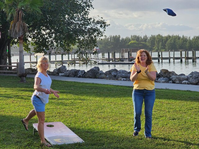 2026 SE Crowberry Dr, Port Saint Lucie, FL 34983 - view of property's community featuring a yard, a water view, and a dock