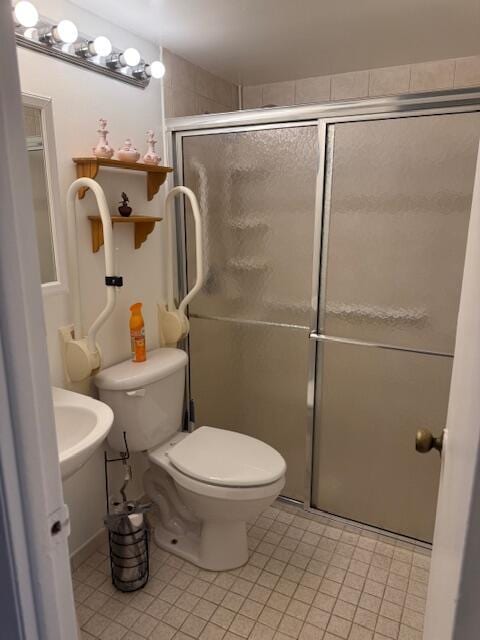 9081 Sunrise Lakes Blvd Unit 112, Sunrise, FL 33322 - bathroom featuring toilet, a stall shower, and tile patterned flooring