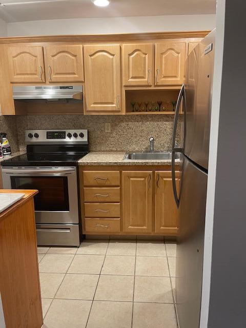 9081 Sunrise Lakes Blvd Unit 112, Sunrise, FL 33322 - kitchen featuring light tile patterned floors, a sink, appliances with stainless steel finishes, under cabinet range hood, and backsplash