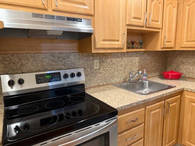 9081 Sunrise Lakes Blvd Unit 112, Sunrise, FL 33322 - kitchen featuring decorative backsplash, electric range, under cabinet range hood, light countertops, and a sink