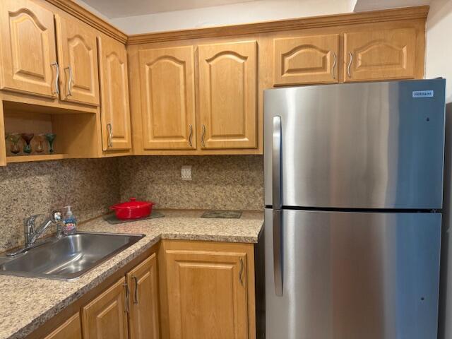 9081 Sunrise Lakes Blvd Unit 112, Sunrise, FL 33322 - kitchen with light countertops, decorative backsplash, freestanding refrigerator, and a sink