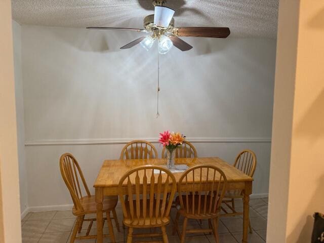 9081 Sunrise Lakes Blvd Unit 112, Sunrise, FL 33322 - dining space featuring light tile patterned flooring, a ceiling fan, a textured ceiling, and baseboards