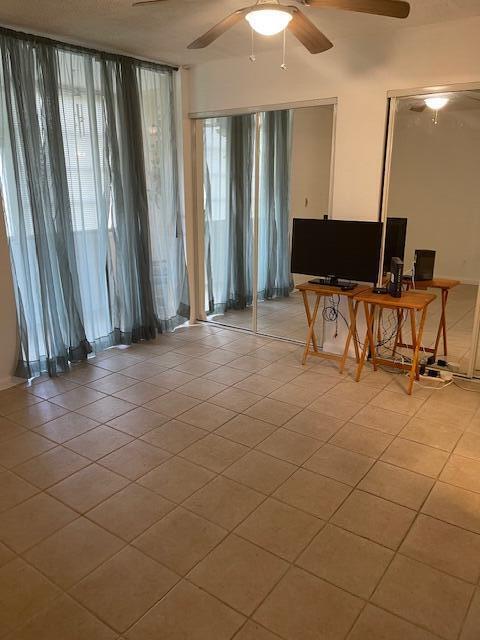 9081 Sunrise Lakes Blvd Unit 112, Sunrise, FL 33322 - living area featuring light tile patterned floors and a ceiling fan