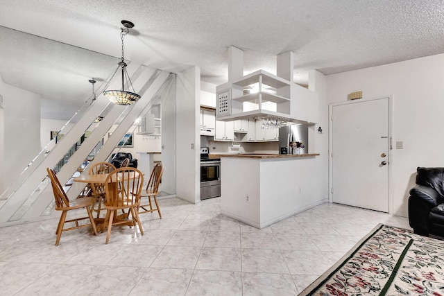 7612 Ashmont Cir Unit 203, Tamarac, FL 33321 - kitchen featuring appliances with stainless steel finishes, a peninsula, a textured ceiling, under cabinet range hood, and open floor plan