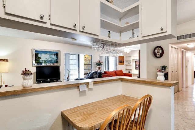 7612 Ashmont Cir Unit 203, Tamarac, FL 33321 - kitchen with white cabinets, light tile patterned floors, open floor plan, light countertops, and open shelves