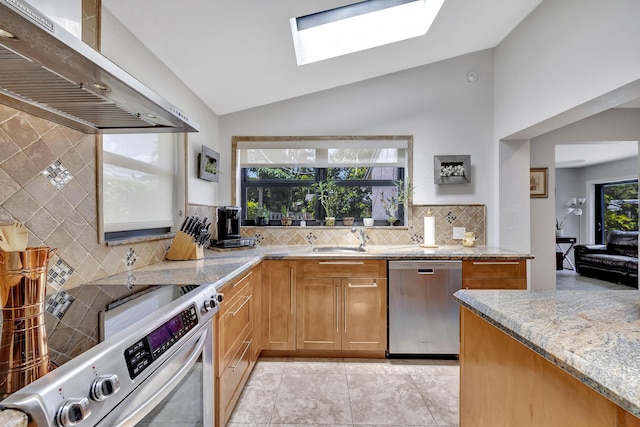 2211 NE 34th Ct, Lighthouse Point, FL 33064 - kitchen featuring backsplash, light stone countertops, lofted ceiling with skylight, stainless steel appliances, and wall chimney exhaust hood