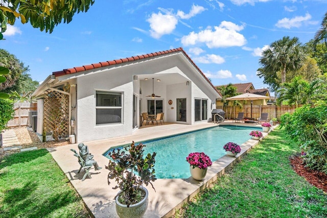 back of property with a fenced backyard, stucco siding, a patio area, and a ceiling fan