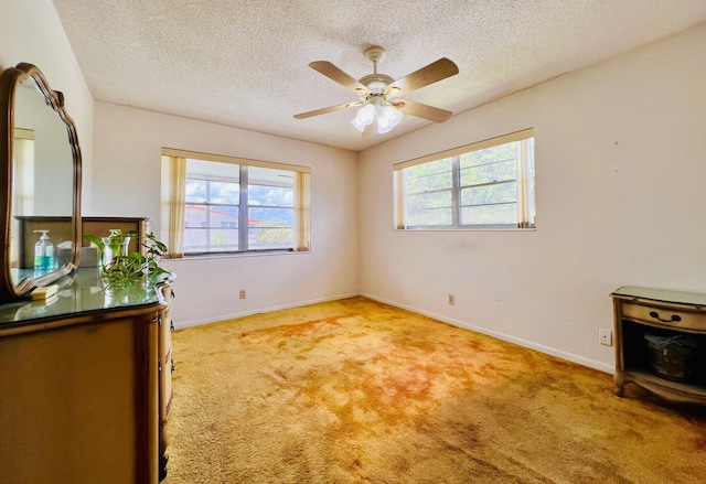66 Andover C, West Palm Beach, FL 33417 - spare room featuring healthy amount of natural light, baseboards, light carpet, a textured ceiling, and a ceiling fan