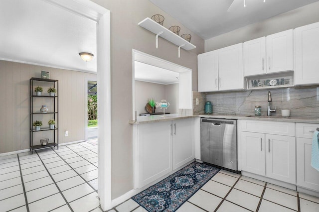 kitchen with a sink, stainless steel dishwasher, light tile patterned floors, white cabinets, and decorative backsplash