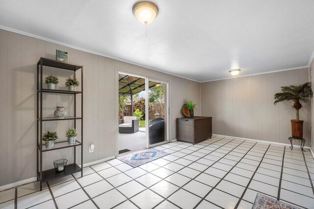living area with baseboards, ornamental molding, and light tile patterned floors