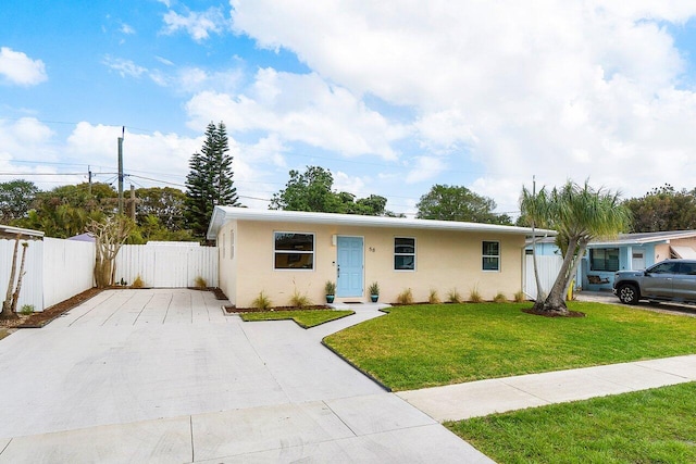 ranch-style home with a front yard, concrete driveway, stucco siding, and fence