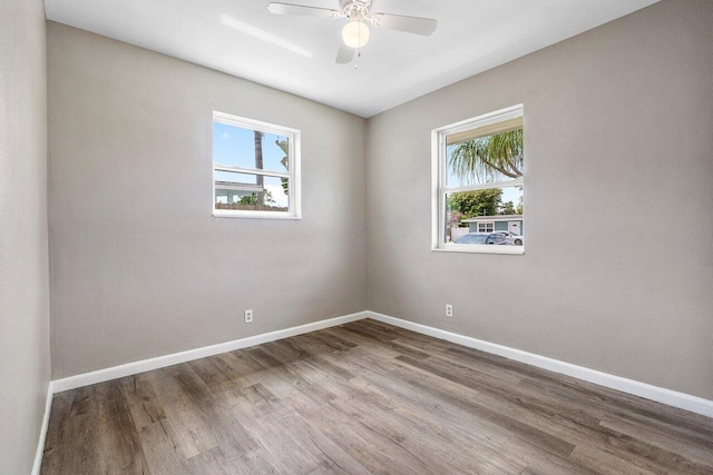 spare room featuring a ceiling fan, baseboards, and wood finished floors