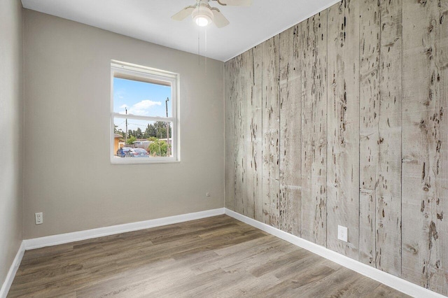 unfurnished room featuring baseboards, ceiling fan, and wood finished floors