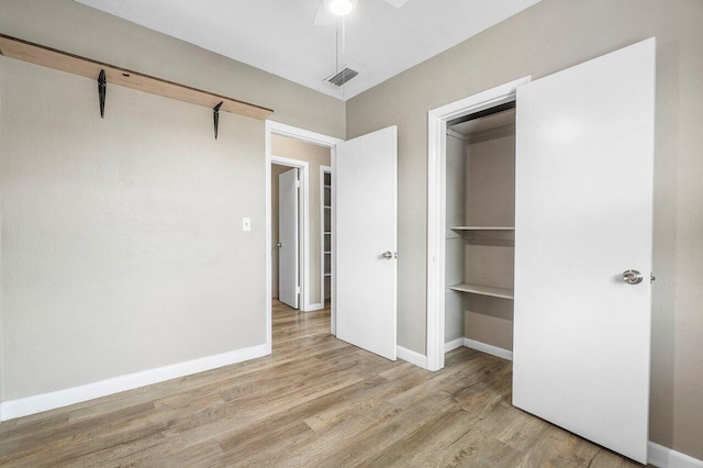 unfurnished bedroom featuring a ceiling fan, wood finished floors, baseboards, and visible vents