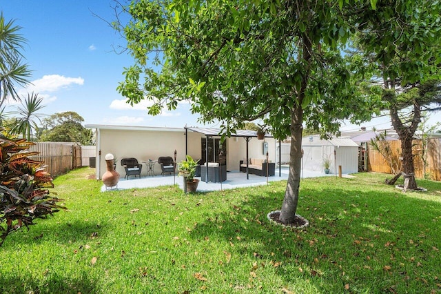 back of property with a fenced backyard, a lawn, stucco siding, and a patio area