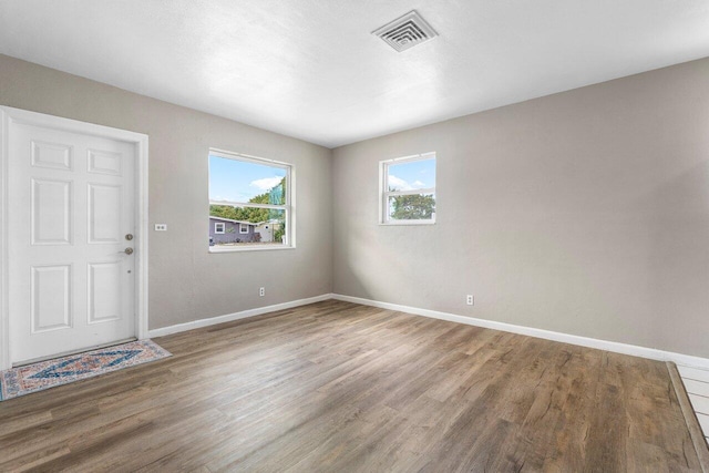 spare room featuring wood finished floors, baseboards, and visible vents