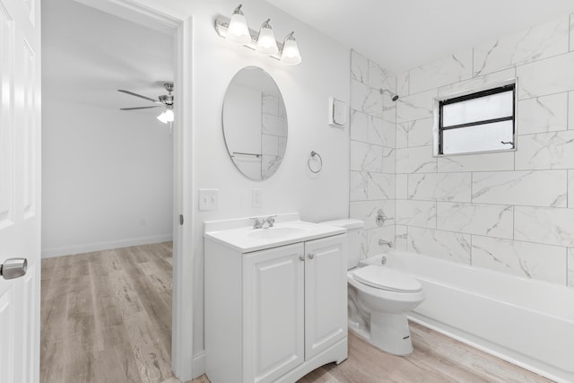 bathroom with ceiling fan, wood finished floors, toilet, vanity, and shower / bath combination