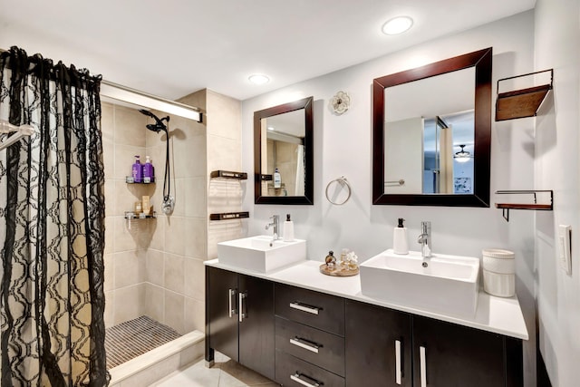 bathroom featuring a stall shower, double vanity, recessed lighting, and a sink
