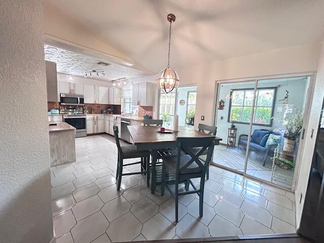 5372 Pine Cir, Coral Springs, FL 33067 - dining room featuring a textured wall, a chandelier, and light tile patterned floors