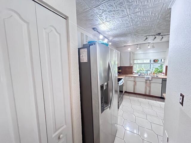 5372 Pine Cir, Coral Springs, FL 33067 - kitchen with stainless steel appliances, track lighting, a textured wall, light countertops, and a sink