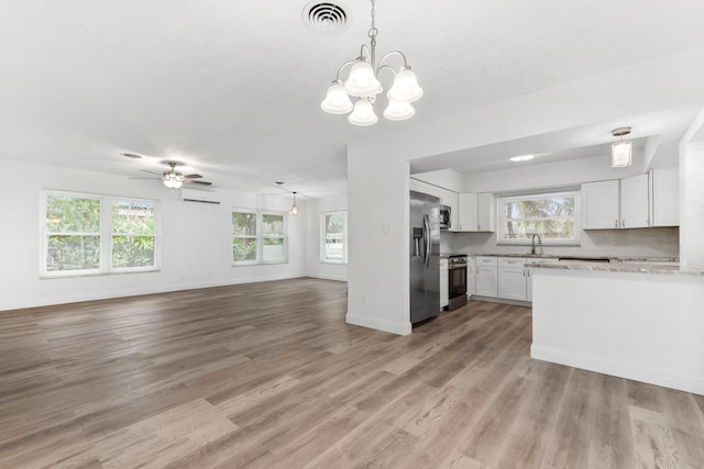 kitchen featuring open floor plan, white cabinetry, stainless steel appliances, visible vents, and light wood-style flooring