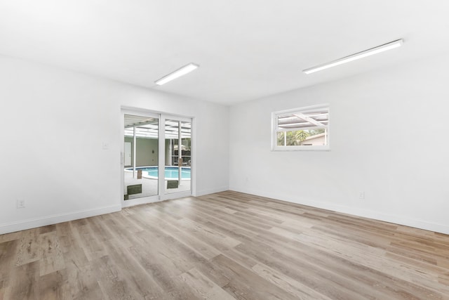 unfurnished room featuring baseboards and light wood finished floors