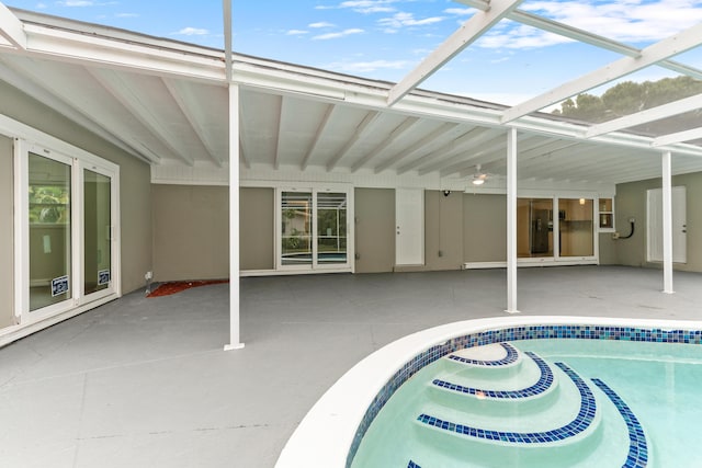 outdoor pool featuring glass enclosure, cooling unit, and a patio area