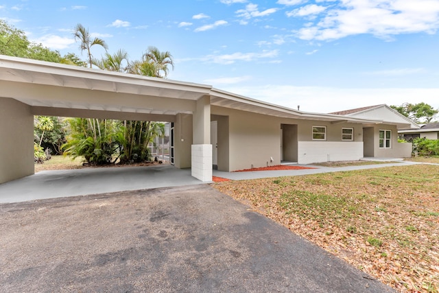 view of front of property featuring stucco siding, aphalt driveway, and a carport