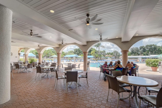5115 Europa Dr Unit P, Boynton Beach, FL 33437 - view of patio / terrace featuring outdoor dining space, a ceiling fan, and a community pool