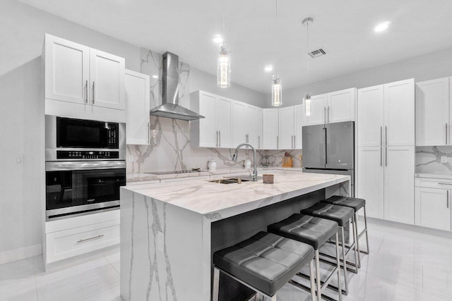 15744 68th Ct N, The Acreage, FL 33470 - kitchen featuring visible vents, wall chimney exhaust hood, a sink, stainless steel appliances, and backsplash
