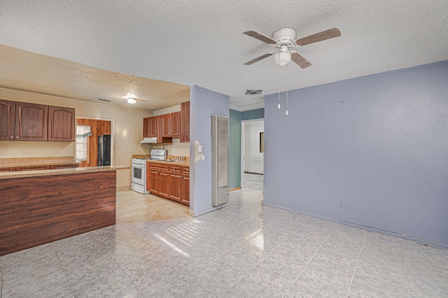 2008 Avenue Ave N, Fort Pierce, FL 34950 - kitchen featuring white range with gas cooktop, light countertops, a textured ceiling, visible vents, and ceiling fan