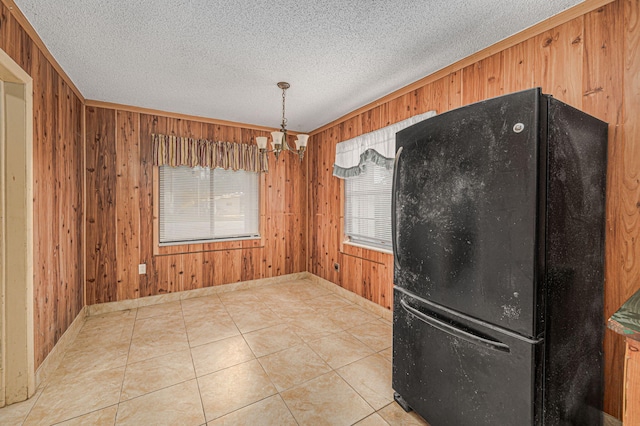 2008 Avenue Ave N, Fort Pierce, FL 34950 - unfurnished dining area with baseboards, a notable chandelier, a textured ceiling, wooden walls, and tile patterned floors