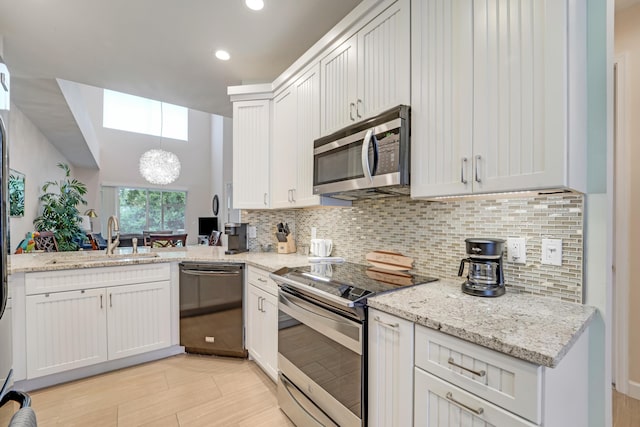 9339 World Cup Way, Port Saint Lucie, FL 34986 - kitchen with appliances with stainless steel finishes, a skylight, a sink, backsplash, and recessed lighting