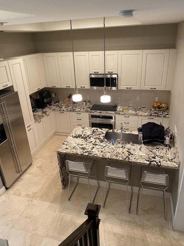8481 NW 51st Ter, Doral, FL 33166 - kitchen featuring a kitchen bar, tasteful backsplash, appliances with stainless steel finishes, white cabinetry, and a sink