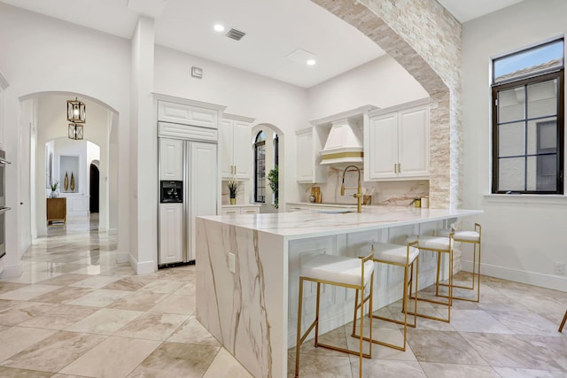 9387 Satinleaf Pl, Parkland, FL 33076 - kitchen featuring a sink, a kitchen bar, visible vents, paneled built in refrigerator, and a peninsula