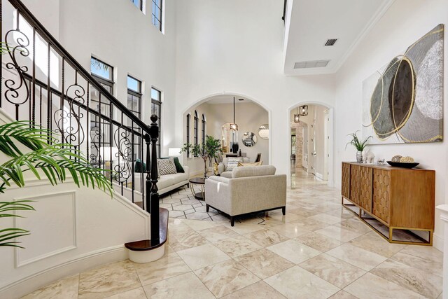 9387 Satinleaf Pl, Parkland, FL 33076 - living room featuring a high ceiling, arched walkways, visible vents, and a healthy amount of sunlight