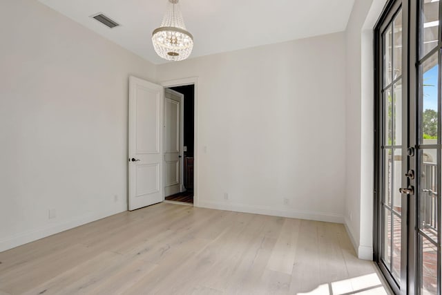 9387 Satinleaf Pl, Parkland, FL 33076 - unfurnished room featuring a chandelier, light wood-type flooring, visible vents, and baseboards