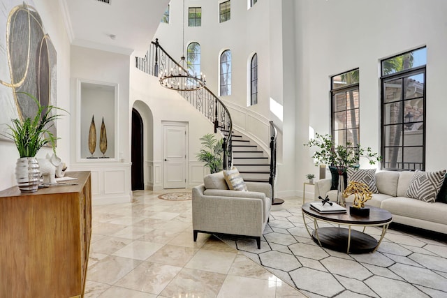 9387 Satinleaf Pl, Parkland, FL 33076 - living area featuring arched walkways, a decorative wall, stairway, a high ceiling, and crown molding