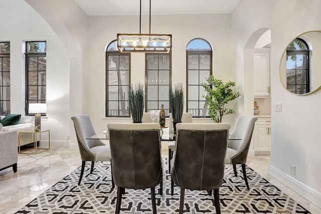 9387 Satinleaf Pl, Parkland, FL 33076 - dining space featuring baseboards, marble finish floor, and arched walkways