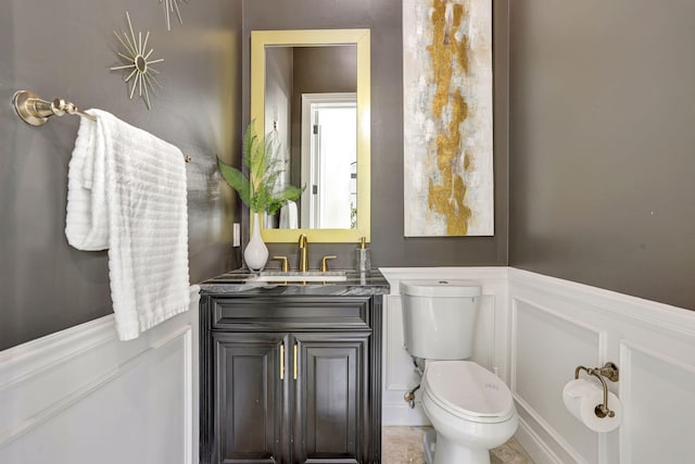 9387 Satinleaf Pl, Parkland, FL 33076 - half bathroom featuring toilet, vanity, a wainscoted wall, and a decorative wall
