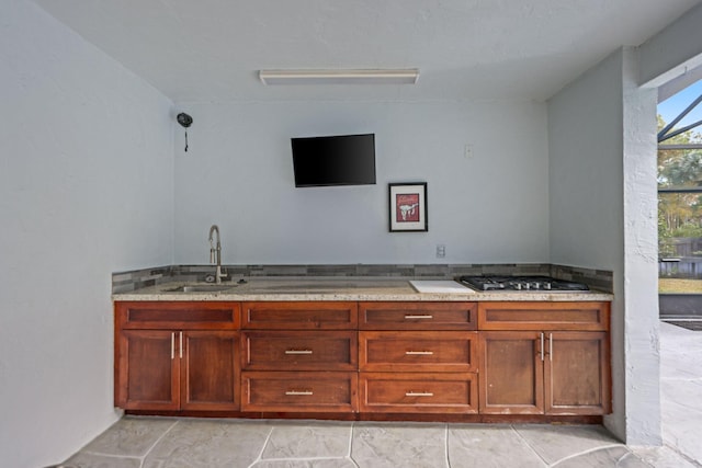 bar featuring a sink and stainless steel gas cooktop
