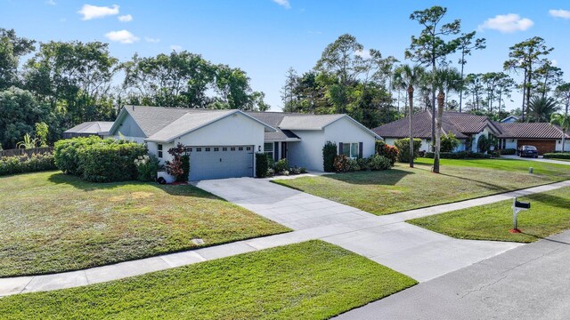 single story home with driveway, a front yard, an attached garage, and stucco siding
