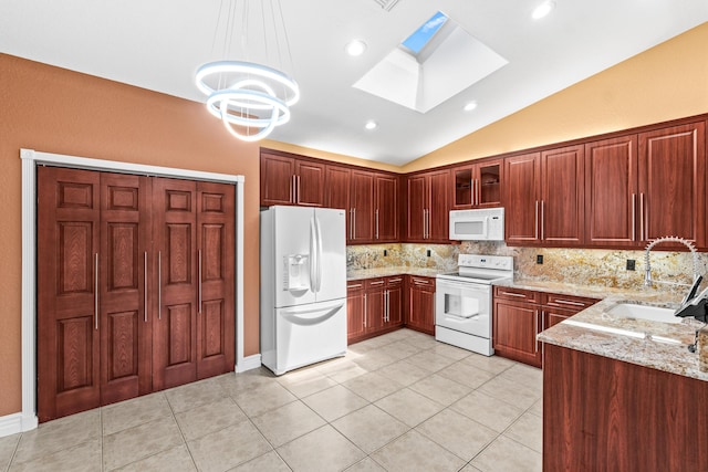 6346 San Michel Way, Delray Beach, FL 33484 - kitchen featuring tasteful backsplash, lofted ceiling with skylight, a sink, white appliances, and light stone countertops