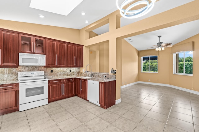 6346 San Michel Way, Delray Beach, FL 33484 - kitchen with light tile patterned floors, a sink, white appliances, lofted ceiling with skylight, and tasteful backsplash