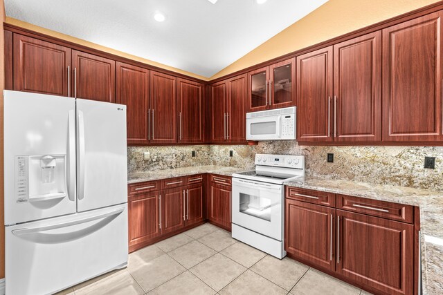 6346 San Michel Way, Delray Beach, FL 33484 - kitchen with lofted ceiling, tasteful backsplash, white appliances, and light tile patterned floors