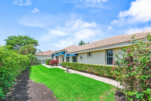 6346 San Michel Way, Delray Beach, FL 33484 - back of house with stucco siding, a tile roof, fence, and a yard